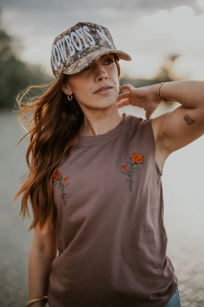 Woman wearing a Wyoming Cowboys Camo hat with bucking horse details.