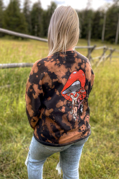 Fun open mouth graphic featuring “WYO” lettering + Indian paintbrush wildflowers “dripping” out. This sweatshirt is a unisex style. The acid wash process provides a unique, washed + worn vintage look. Also has a raw edge bottom hem. 