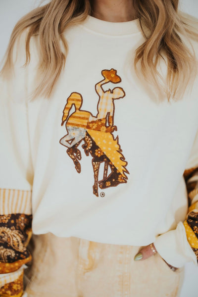 Woman poses in elevated University of Wyoming game-day sweatshirt 