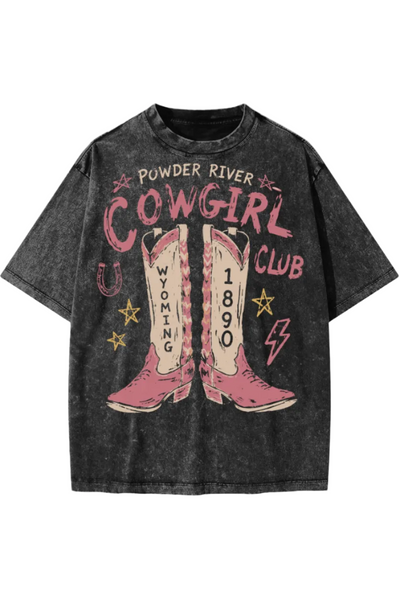A dark gray acid-wash graphic t-shirt featuring a western 'Cowgirl Club' theme with pink cowboy boots, yellow stars, and text reading 'Powder River' and 'Wyoming'.