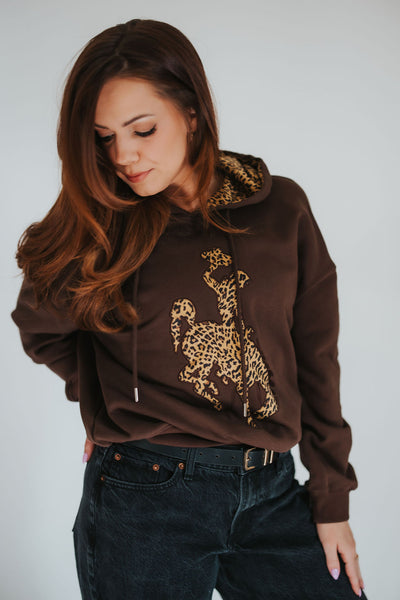 Woman looks over her shoulder in her unique, story-led Stay WYLD hoodie from RUBY WYLD