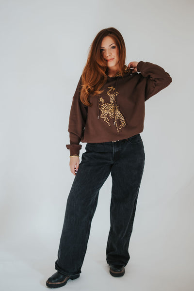 Woman adjust her cheetah print hood on her RUBY WYLD Cowboys sweater 