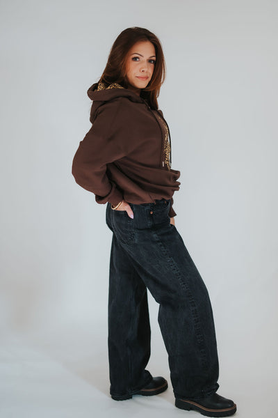 Woman looks at the camera and puts her hand in her pocket as she wears her elevated University of Wyoming apparel 