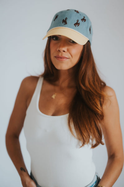 Denim and yellow dad hat with all-over Wyoming cowboys steamboat bucking horse embroidery