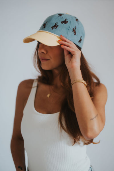 Denim and yellow dad hat with all-over Wyoming cowboys steamboat bucking horse embroidery