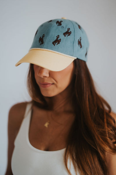 Denim and yellow dad hat with all-over Wyoming cowboys steamboat bucking horse embroidery