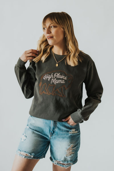 Wyoming modern cowgirl runs fingers through her hair as she shows off her custom embroidered, charcoal motherhood crewneck