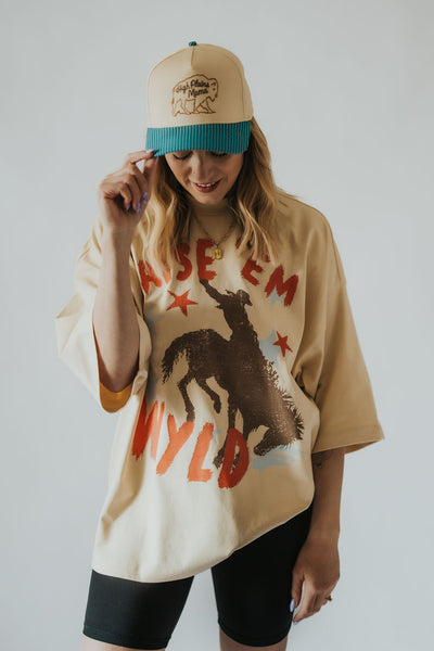 Owner of RUBY WYLD boutique in Casper Wyoming models oversized "raise 'em Wyld" t-shirt with bucking horse and stars on the front 