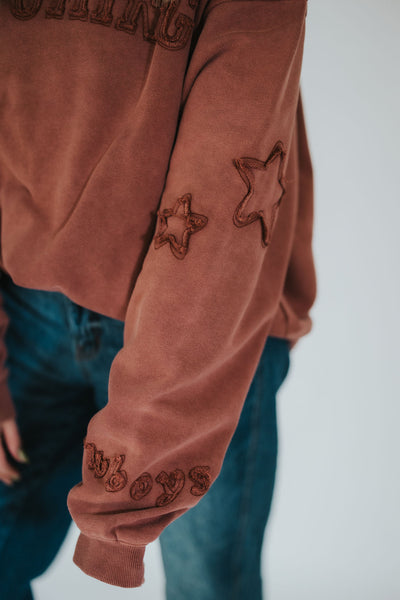Wyoming woman showcases the sleeve detailing on her custom, licensed University of Wyoming hoodie 