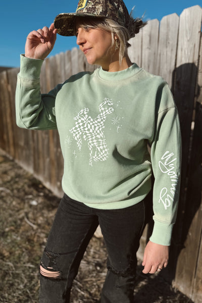 We love a good bucking horse sweatshirt. This one is leveled up with it's checkered fill, glimmers and "Wyoming" text along the sleeves. This cutie is hand stamped in Wyoming with high quality fabric ink. University of Wyoming. 