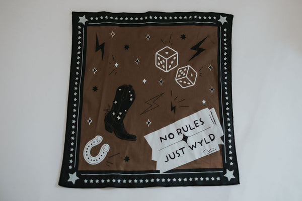 RUBY WYLD's "No Rules, Just WYLD" bandana is layed out fully against a white backdrop showing off it's intricate western lifestyle designs and details