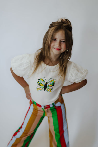 This is the perfect tee for girls that can be worn for any occasion. Features a round neckline + puff sleeves from a gauzy 100% organic cotton fabric. Pair with a skirt, leggings, or our fun striped Corduroy Crop Pants to complete the look!