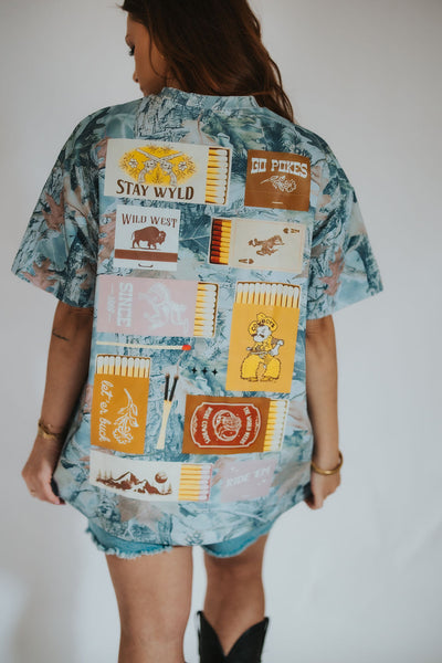 woman poses to the back in her custom RUBY WYLD oversized women's camo t-shirt with Wyoming matchbook detailing and designs