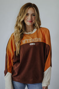 Brushed fleece pullover ”WYOMING EST. 1890” embroidery Brown, gold + white color-blocking  Relaxed, loose fit Ultra-soft