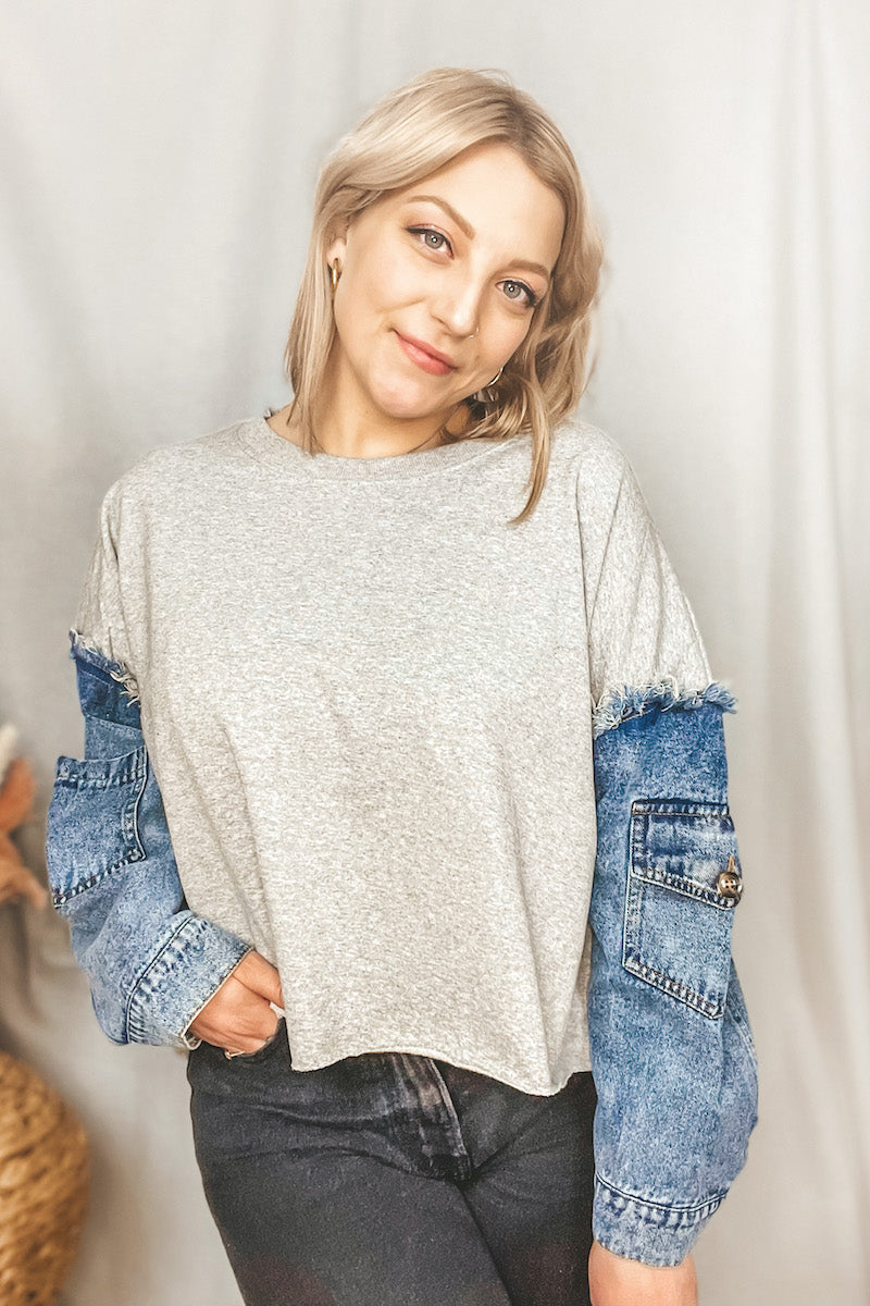This oversized cutoff crewneck is so unique with its contrast denim pocket sleeves. It features a ribbed crewneck + distressed details, like the exposed frayed hem at the shoulders and raw edge cut cropped hem
