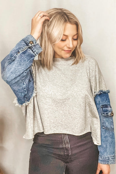 This oversized cutoff crewneck is so unique with its contrast denim pocket sleeves. It features a ribbed crewneck + distressed details, like the exposed frayed hem at the shoulders and raw edge cut cropped hem.