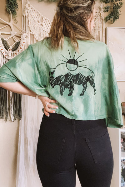 buffalo design. oversized crop fit. sage wash hand dyed fabric. exposed seam detailing. hand stamped with love in Wyoming. relaxed, boxy fit. mustard seed. 